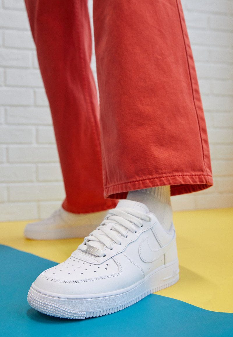 Stylish all-white Nike Air Force 1 sneakers for men & women.
